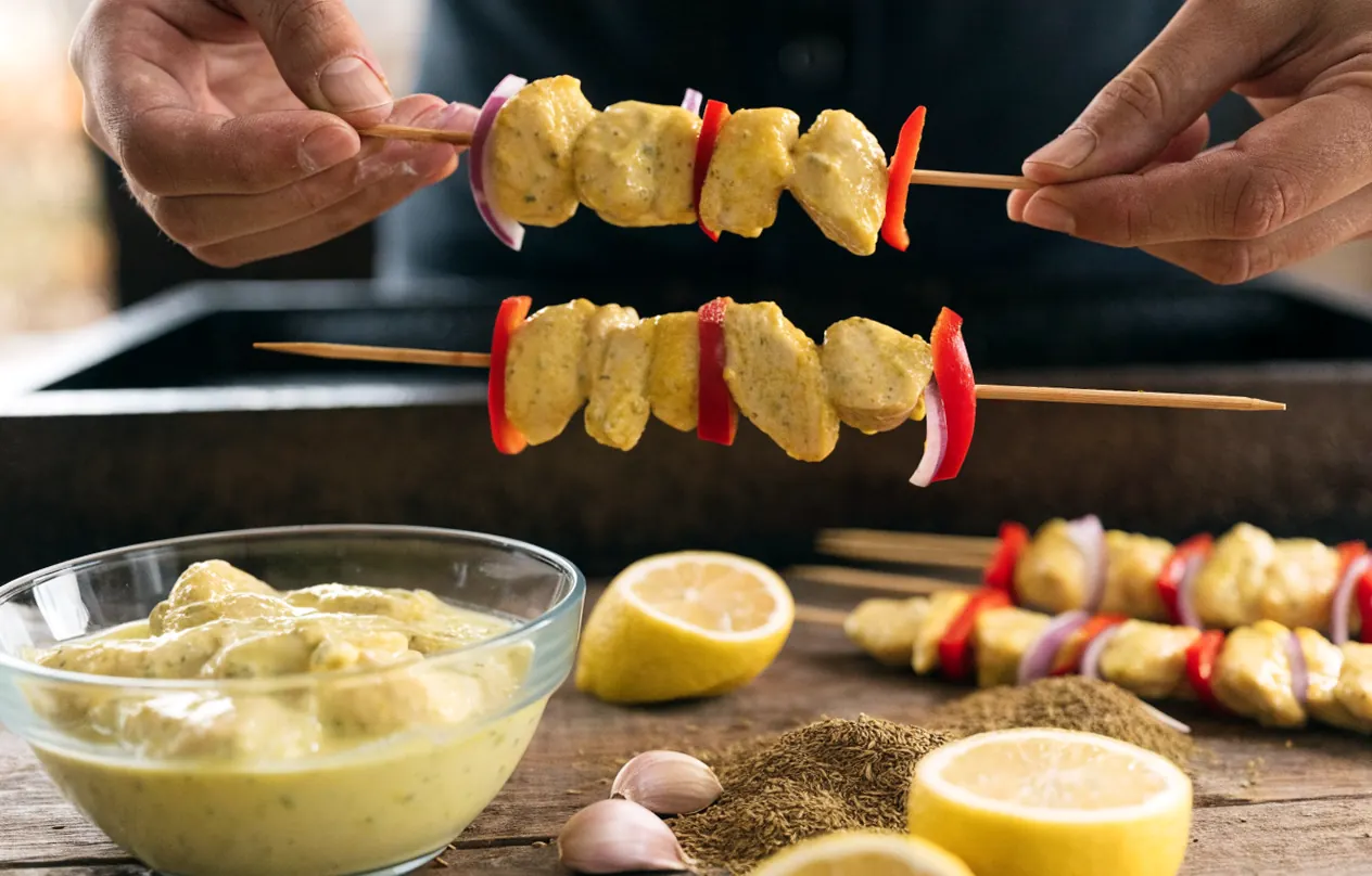 Montage des brochettes : escalopines halal marinées enfilées sur des piques avec poivron et oignon rouge