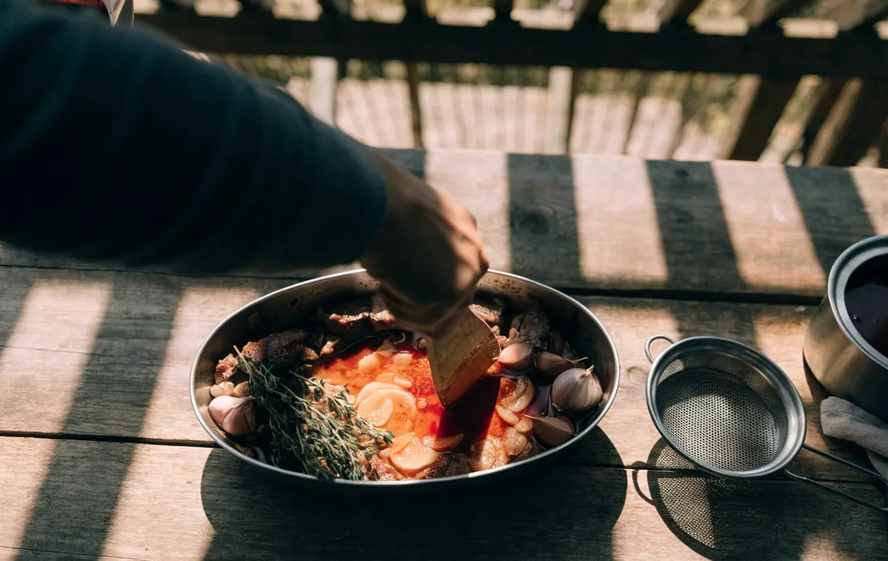 Déglaçage au vin rouge des sucs et parures pour préparer le jus du rôti de bœuf