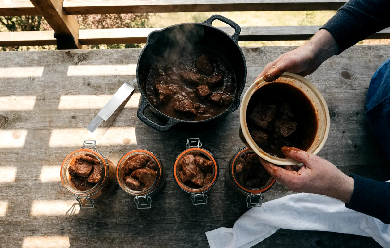 Remplissage des bocaux de daube avec un entonnoir avant la stérilisation des plats cuisinés