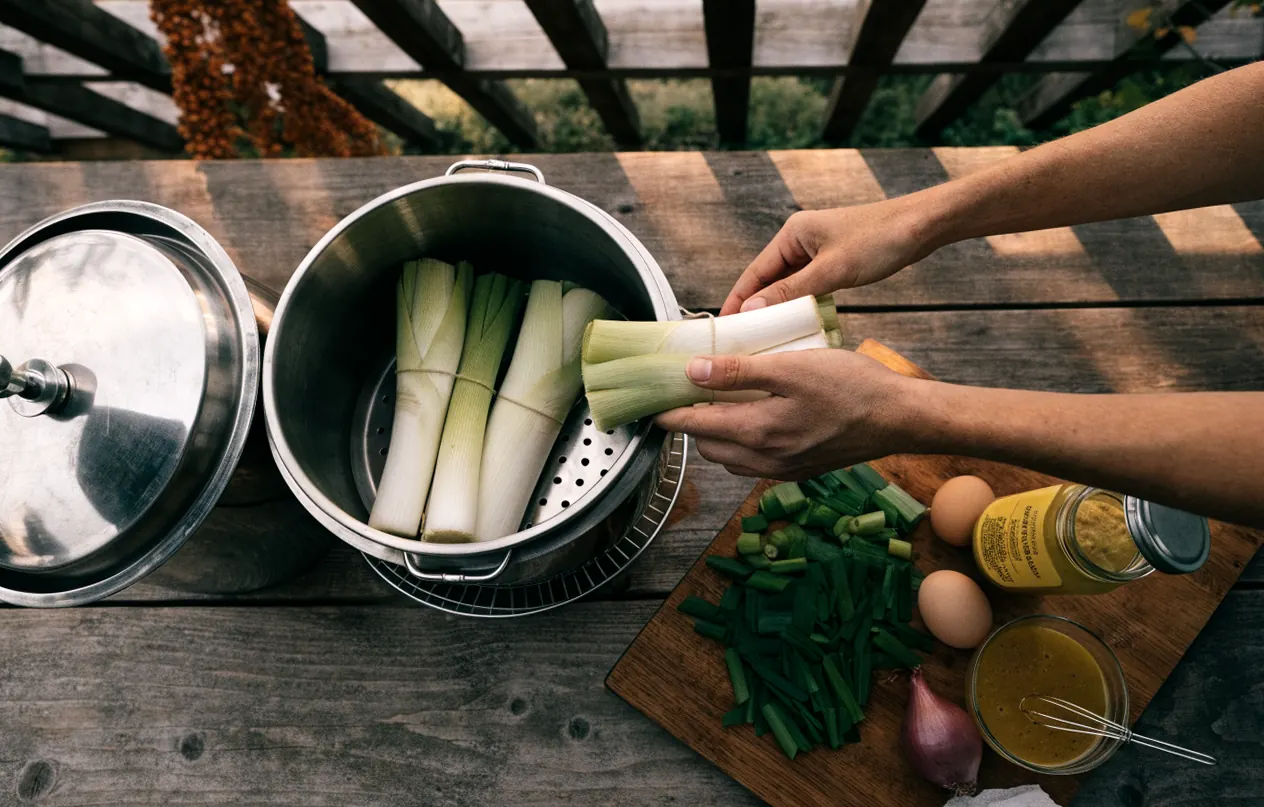 Poireaux ficelés en bottes dans le panier vapeur de la cocotte-minute avant la cuisson