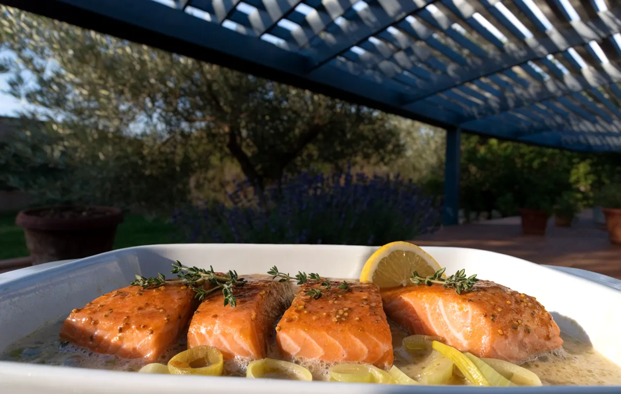 Mustard and honey sauce for baked salmon, served on a bed of leeks in a dish under a pergola