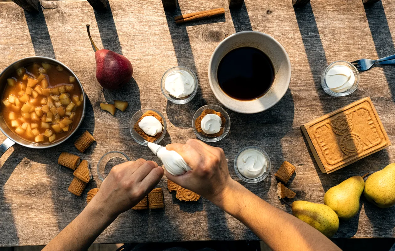 Montage du tiramisu en ramequin : crème au mascarpone pochée sur les spéculoos imbibés, poires poêlées à côté